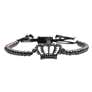 Macro detail of gunmetal crown charm with micro-paved zircons on braided beaded bracelet