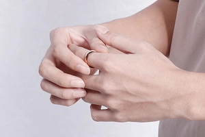 Close-up of a minimalist rose gold stainless steel ring worn on a finger with a matte finish