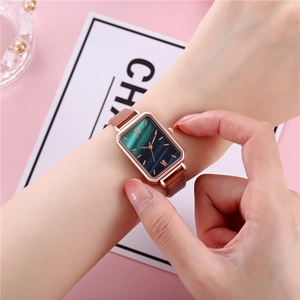 Detail of square rose gold watch with malachite green dial and brown leather strap