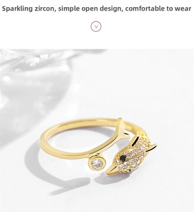 Close-up of golden dolphin ring with sparkling zircon stones and adjustable open band