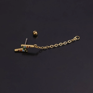 Detail of lightning bolt earring with colorful cubic zirconia and gold chain on black