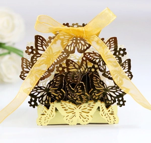 Detailed laser-cut butterfly candy box in gold finish with elegant yellow ribbon bow
