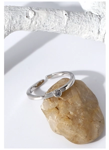 Dettaglio macro di un anello regolabile in argento con zircone su pietra naturale