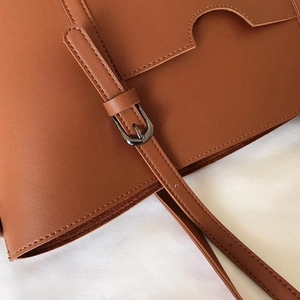 Brown PU leather tote bag with adjustable strap and detailed stitching for women