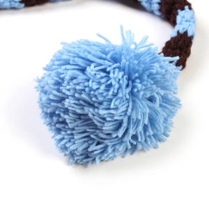 Detail of a large blue pom-pom with knit brown and blue textured yarn for baby photo outfits