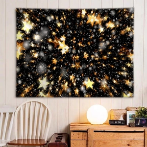 Detail of starry night tapestry hanging over a wooden desk with a warm glowing lamp
