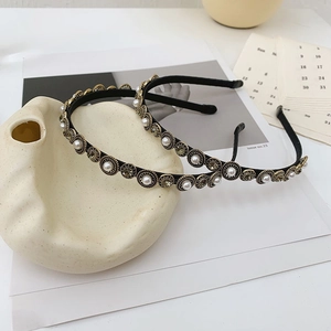 Detail of baroque headband with gold-rimmed pearls and gray crystal embellishments