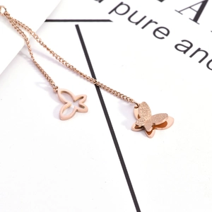 Collier en acier titane avec pendentifs papillons ajourés et sablés en or rose
