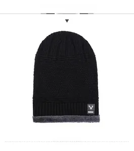 Detail of winter knit beanie showing thick black outer fabric and grey fleece lining