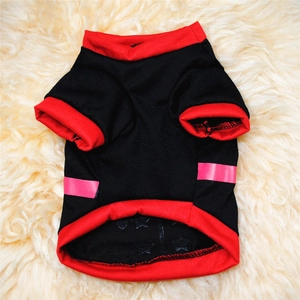 Flat lay of black and red knit cotton dog t-shirt on soft plush white carpet