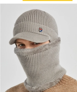Close-up of grey winter knit hat with soft faux fur lining and shield badge detail