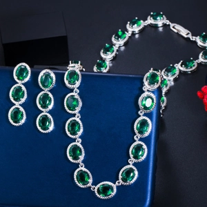 Elegant emerald green zircon necklace and drop earrings set on a dark backdrop