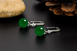 Macro shot of green agate earrings with sparkling pavé cubic zirconia on silver hooks