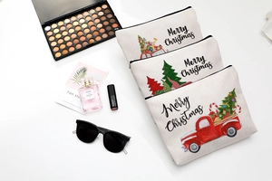 Flat lay of three beige Christmas linen cosmetic bags with festive prints and makeup items