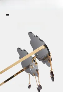 Detail of cloud-shaped sunglasses with metal rain drop pendants and golden frames