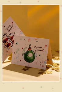 Detailed view of Christmas card featuring cartoon festive bauble and candle illustrations