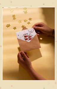 Macro view of Christmas card with stocking illustration being taken out of brown envelope