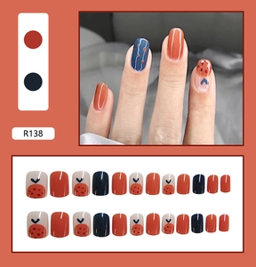 Detail of R138 press-on nails featuring vintage red and navy blue hand-painted patterns
