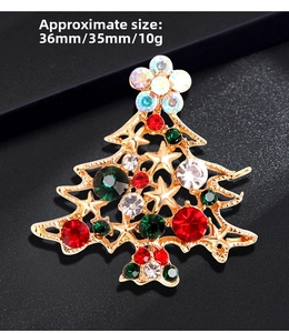 Macro shot of gold Christmas tree brooch with red and green crystals on black background