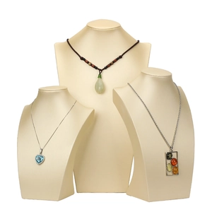 Three premium bust displays with heart, teardrop, and amber necklaces in professional studio setup
