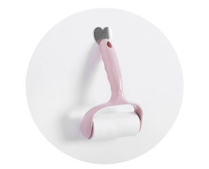Close-up of pink lint roller hanging on a heart hook for efficient garment cleaning