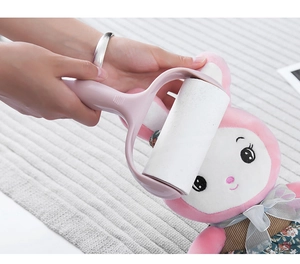 Detail of pink lint roller removing hair from a plush rabbit toy on gray background