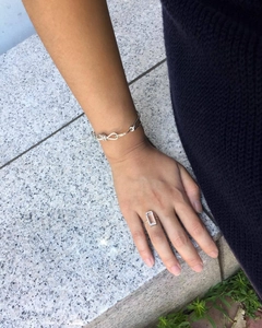 Detail showing the 925 sterling silver knotted bracelet and large rectangular zircon ring