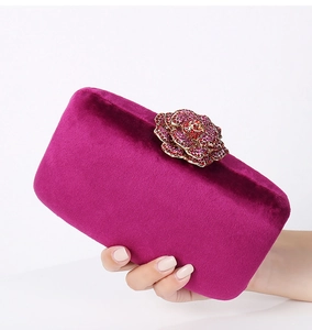 Detailed view of magenta velvet clutch featuring a crystal-encrusted 3D rose clasp