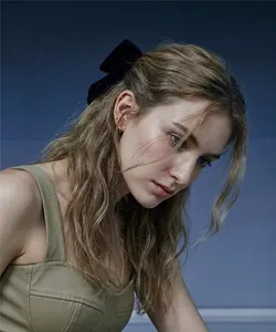 Dettaglio di due fermagli per capelli con fiocco in velluto nero sui capelli di una ragazza