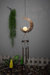 Outdoor solar moon wind chime with bronze hollow design and warm glowing crackle glass ball