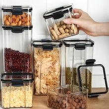 Set of clear plastic food storage containers with black airtight lids on a kitchen counter