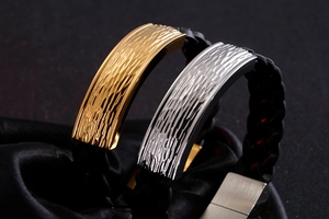 Detail of woven leather bracelets featuring hammered gold and silver curved metal plates