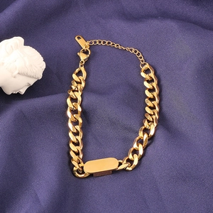 Macro view of gold-plated thick Cuban link bracelet featuring a blank rectangular metal bar