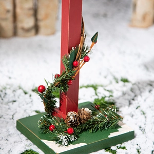 Rustic wooden Christmas ornament with pine needles, red berries, and snow base decoration