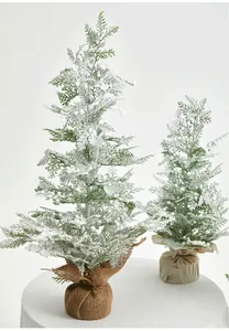 Detail of snowy PE flocked mini Christmas trees with white berries and burlap base wrap