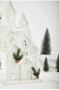 Close-up of white wooden Christmas house decor with pine needles and red berries
