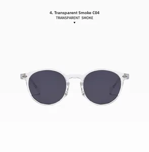 Detail view of round transparent grey sunglasses with smoke lenses and metal hinges