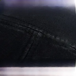 Close-up of premium black knit cotton fabric and precise stitching detail on flat top hat