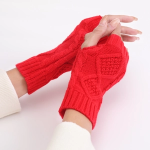 Detail of red cable-knit fingerless gloves showing thick diamond pattern texture