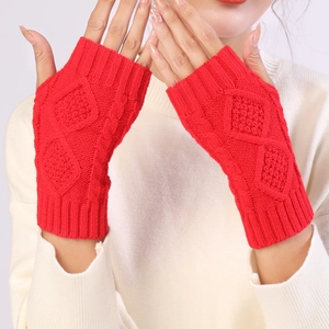 Detail of red cable knit fingerless gloves showing intricate diamond textured patterns