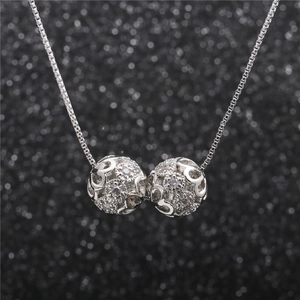 Silver necklace with dual interlocking hollow spheres set with sparkling green cubic zirconia