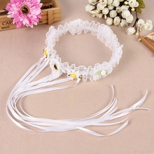 Detailed view of a white lace headband with satin ribbons and daisy flower accents