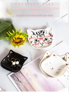 Detailed view of cat-shaped ceramic jewelry trays with gold ears on marble background