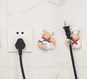 Close-up of creative chef-shaped power cord hooks for kitchen plug organization