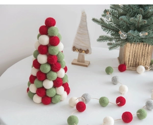 Detail of wool felt Christmas tree and ball garland on wooden base for home decor