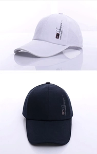 Detail view of cotton baseball caps showing side badge and premium stitching in navy and white