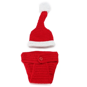 Detail of handmade crochet baby Christmas hat and red knit diaper cover with white pom pom