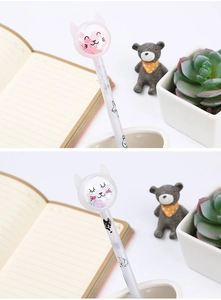 Close-up detail of a cute cartoon cat gel pen featuring sparkling sequins in the topper