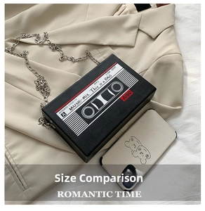 Detail view of retro cassette tape clutch bag with silver chain and smartphone for size