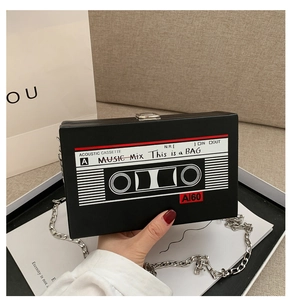 Macro detail of creative cassette shaped crossbody bag with slogan print and silver chain